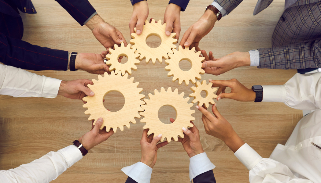 Hands holding cogs in a machine