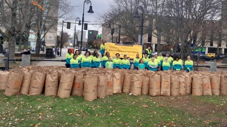 Group posing with lawn bags after clean up at Veterans Park 
