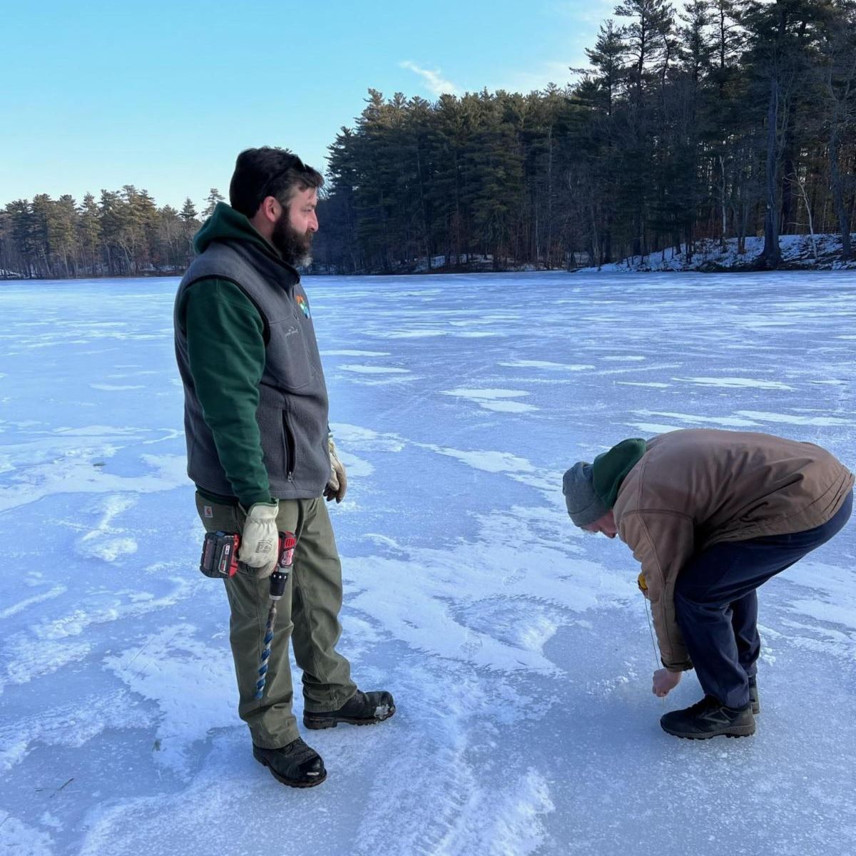 Two employees measuring the ice depth at Dorrs Pond 