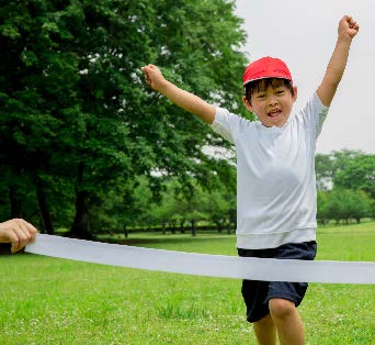 Image of a boy with his hands up cand running