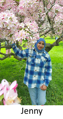 Young brown woman wearing a teal hijab standing next to a cherry blossom tree in bloom