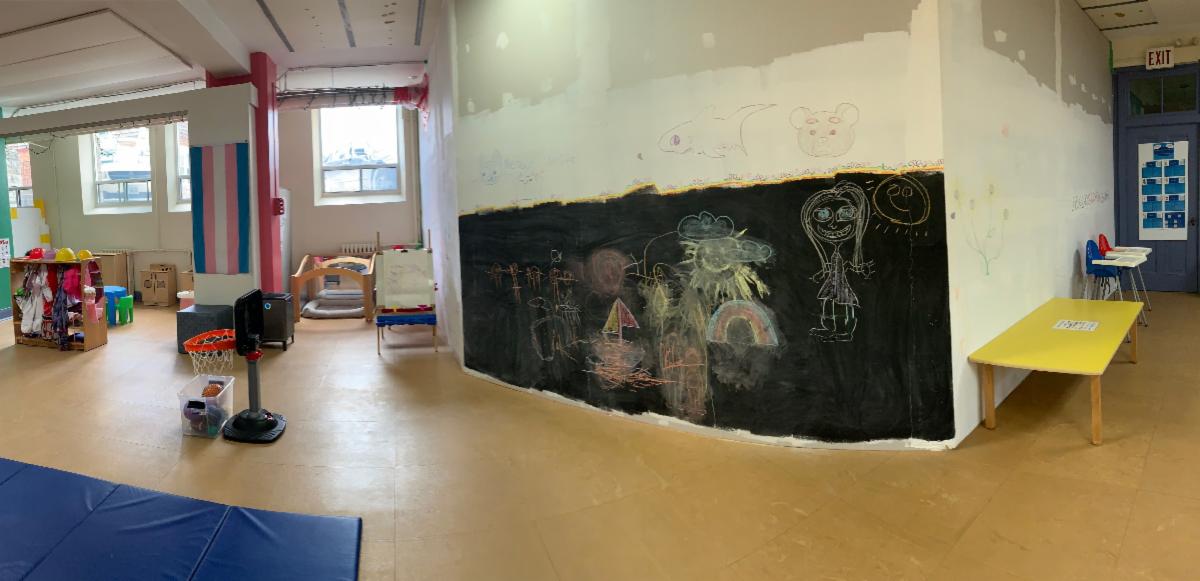 indoor play space with a large black chalkboard wall