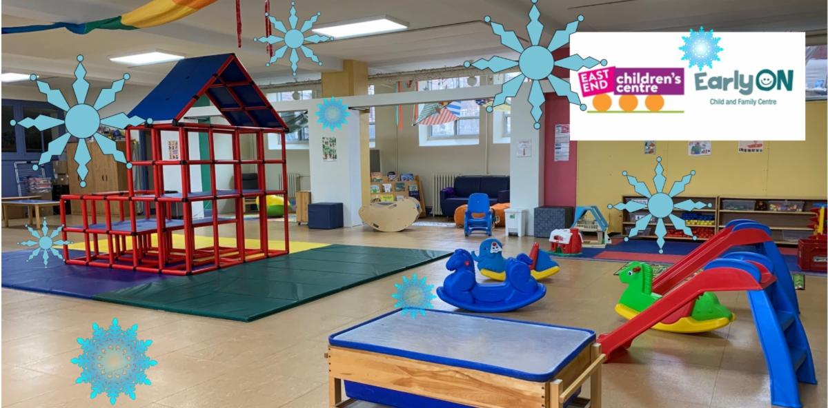 children's indoor play space with red climbing structure on the left and toddler slides on the right with snowflake cliparts scattered