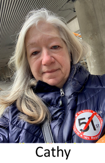 Elder female with long white hair wearing a winter coat and a lapel sticker indicating no 51st state