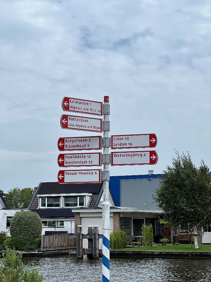 Wayfinding signs in the Netherlands indicating direction and distances for several cycling destinations.