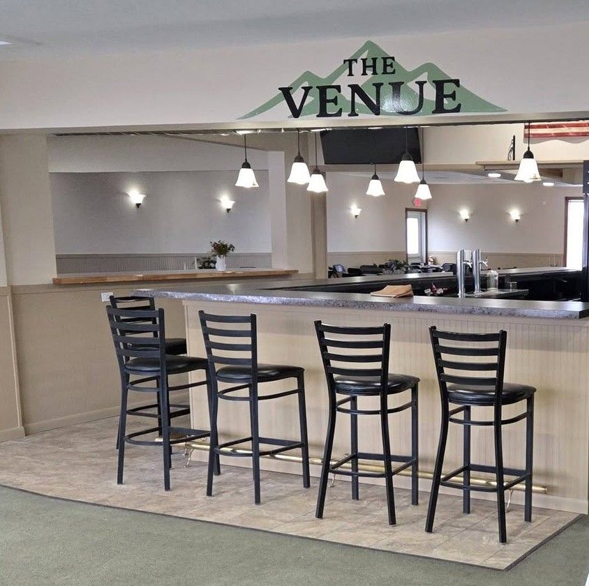 An interior image of the Venue at Skyline, with the bar in the foreground and the banquet area in the background.