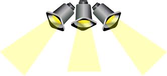 Graphic is of 3 theatrical spotlights shining with yellow beams coming down