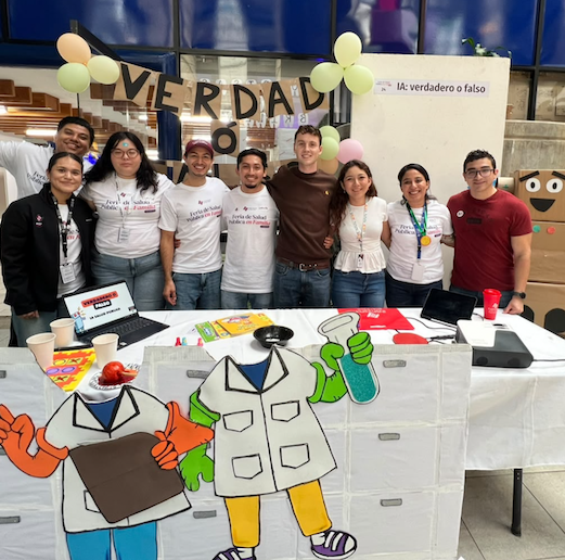 Luke Monnich in a group photo in front of a table at a public health event.