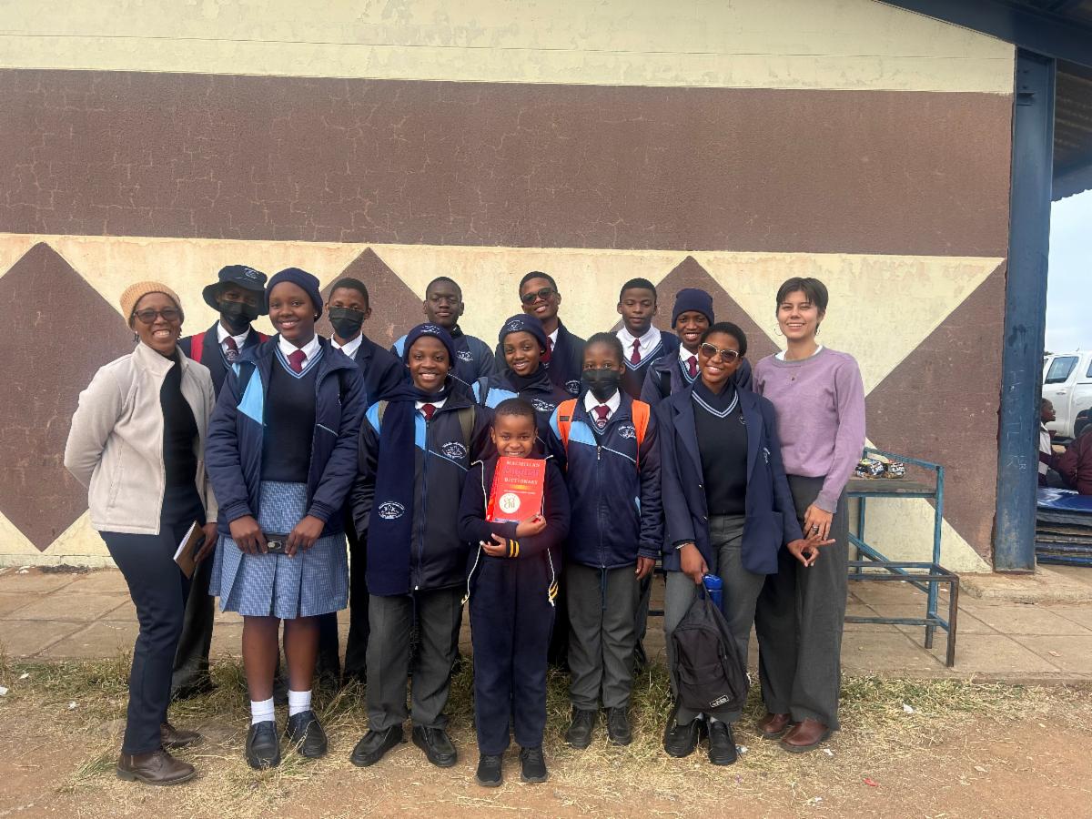 A group photo of students with their teachers outside of building