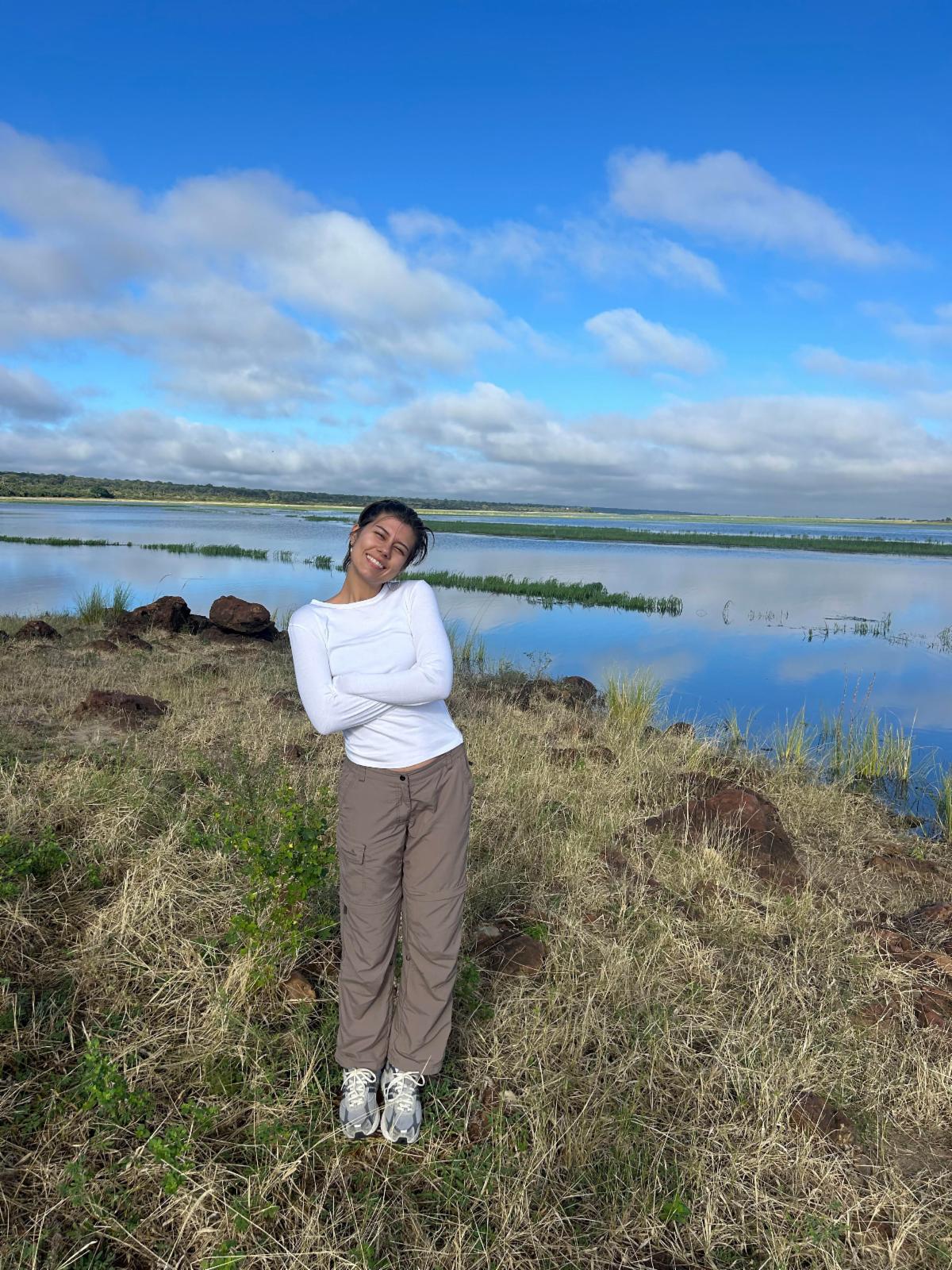Viktoria Hengelbrok stands in an outdoor setting with grass, water, and blue sky behind her.
