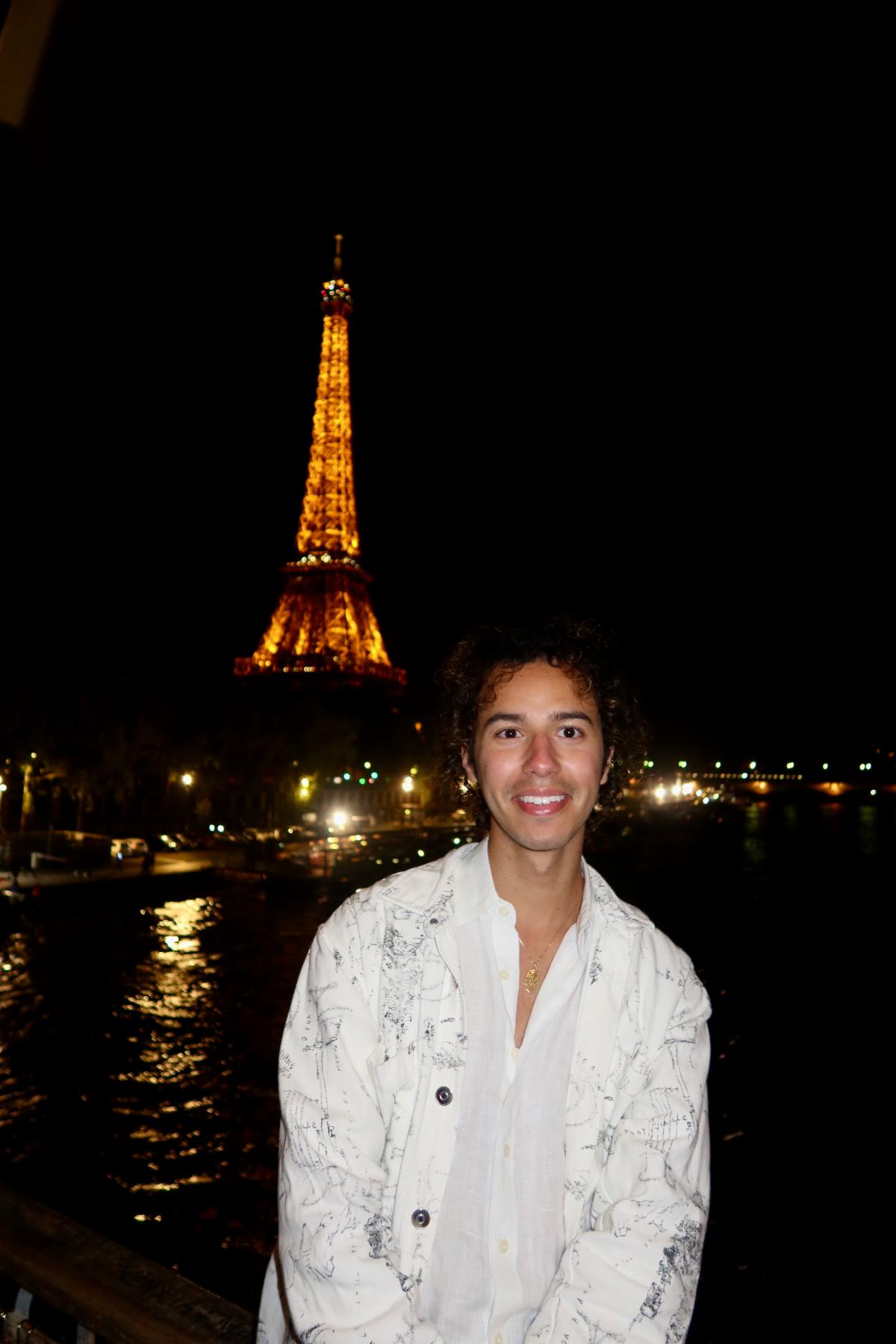 Nadim Oubenali in front of the Eiffel Tower in Paris at night