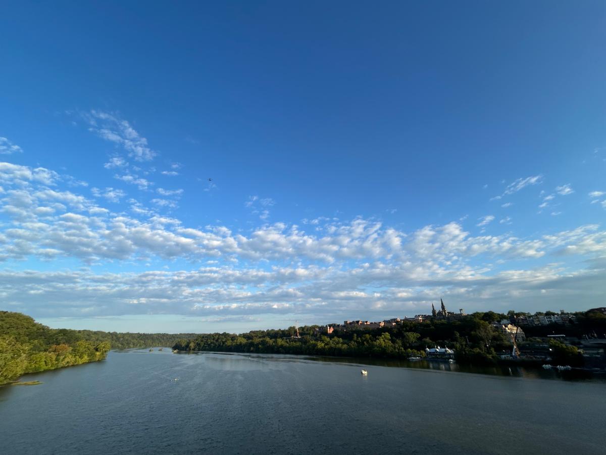 The Potomac River and campus from the Key Bridge with blue sky and clouds - photo by Cessato