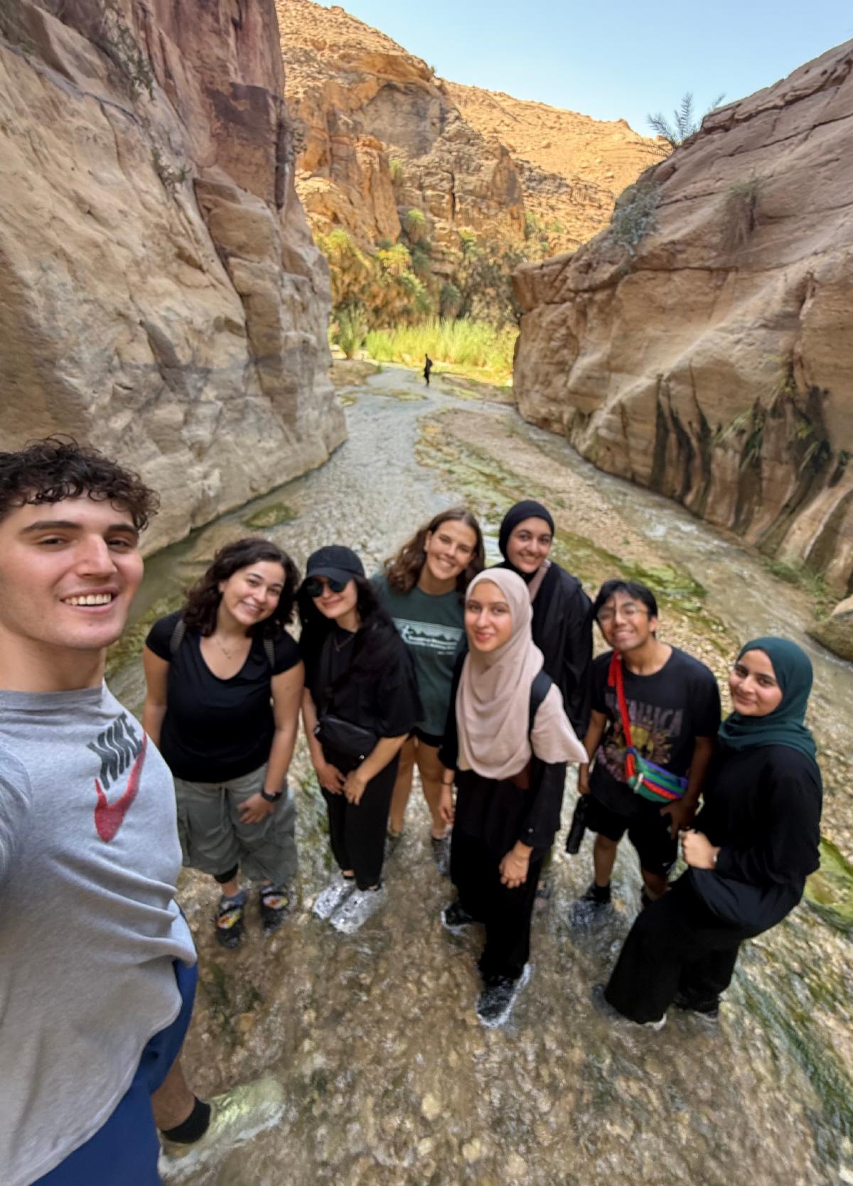 Janeeta Shaukat and several individuals pose in front of a rocky area