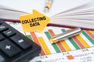 graphs, a calculator, a pen, a notebook and a yellow arrow with the following text in black: Collecting Data