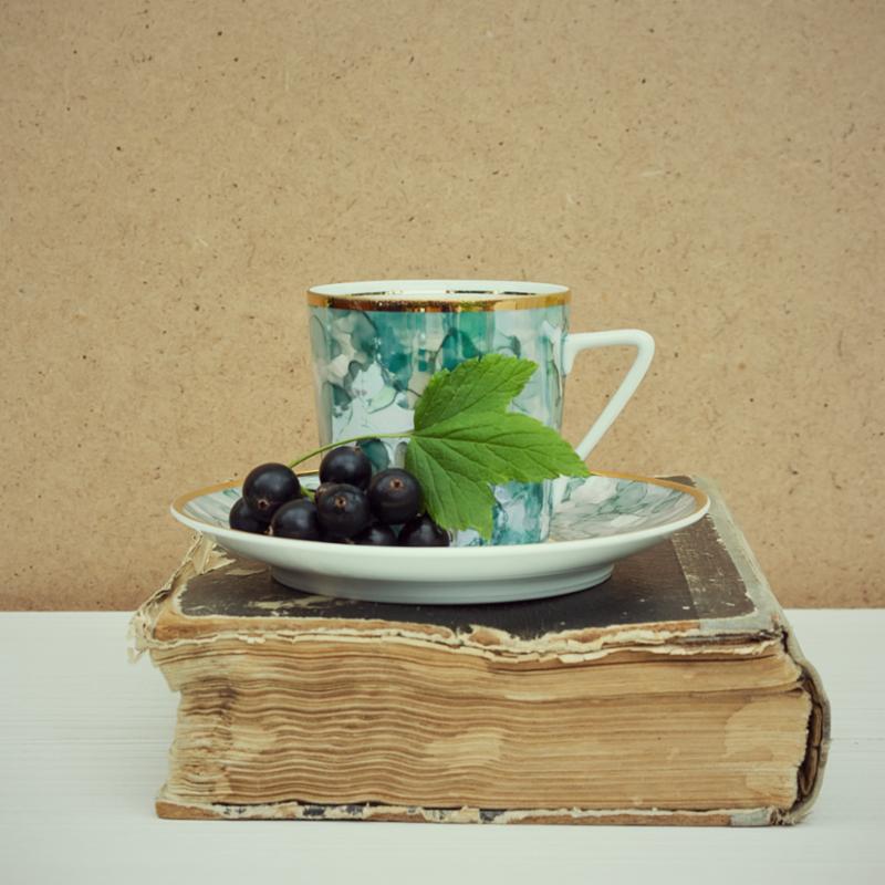 tea cup and saucer sitting on old book