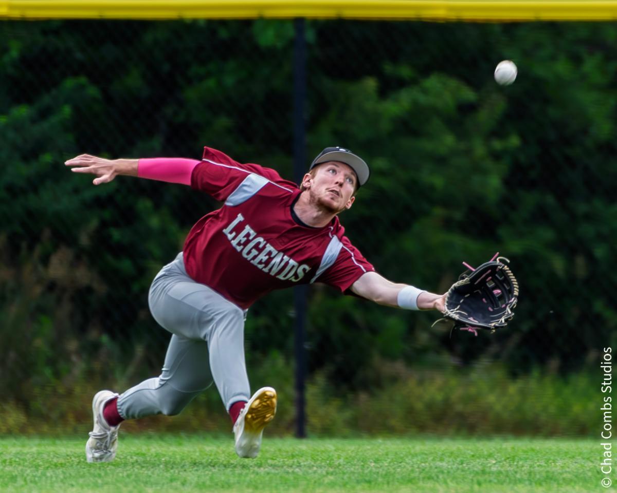 Ban Johnson Legends OF Justin Phillips (Seaman - Baker) lunges for a fly ball.