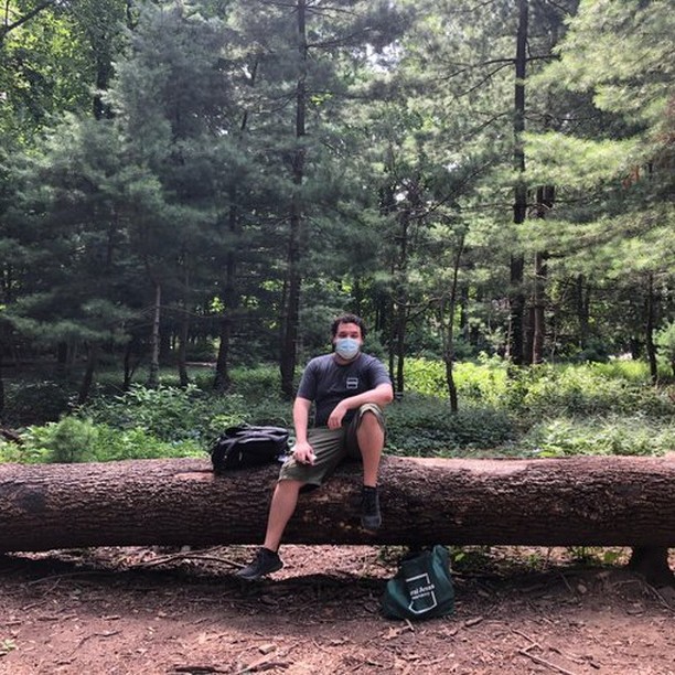 A student sitting on a tree log