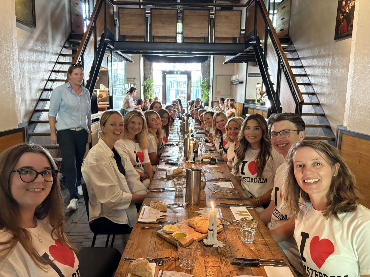 A picture of Dr. Erin Richard with her summer study abroad students sitting at a table for lunch.