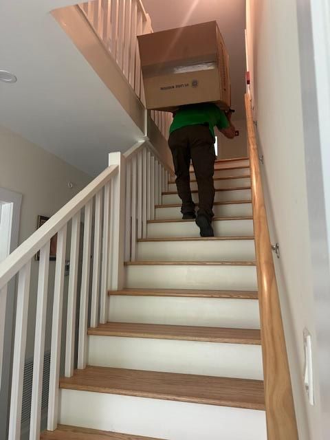 person carries box upstairs