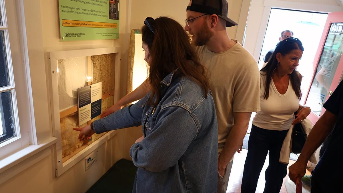 Three people looking at exhibits in a tiny home space.