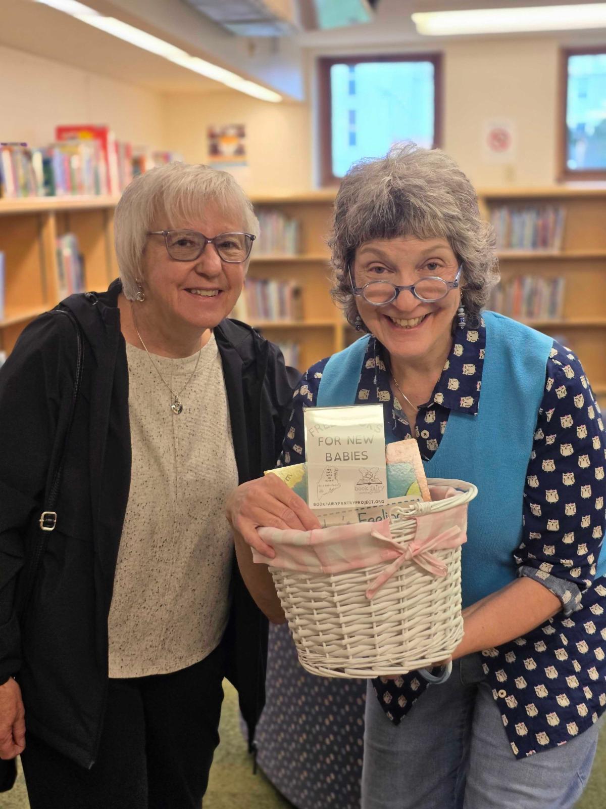 Author Jeanine Deas and Children's Librarian Liz Davis presenting the basket holding board books.
