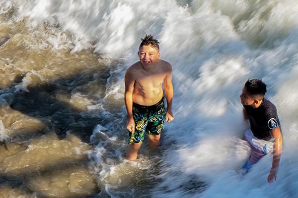 Happy boy playing in the surf