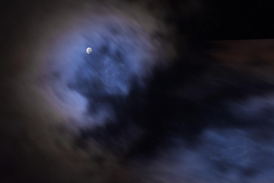 Tiny Moon peeking out behind the clouds