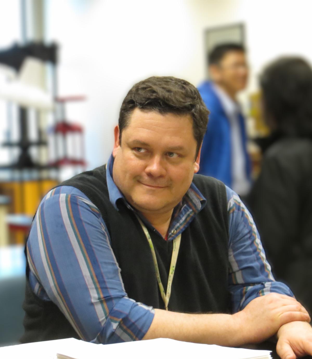William Ulate Rodriguez sits at a table, smiling.