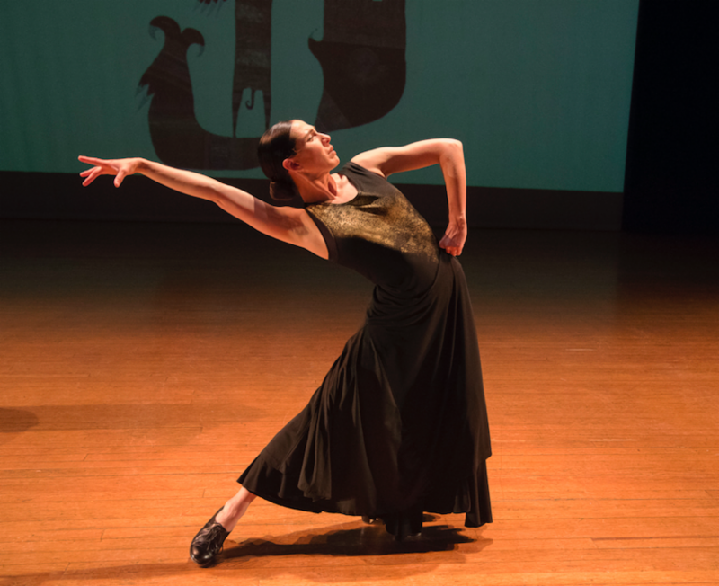 a woman dances dramatically with a leg stretched out to one side