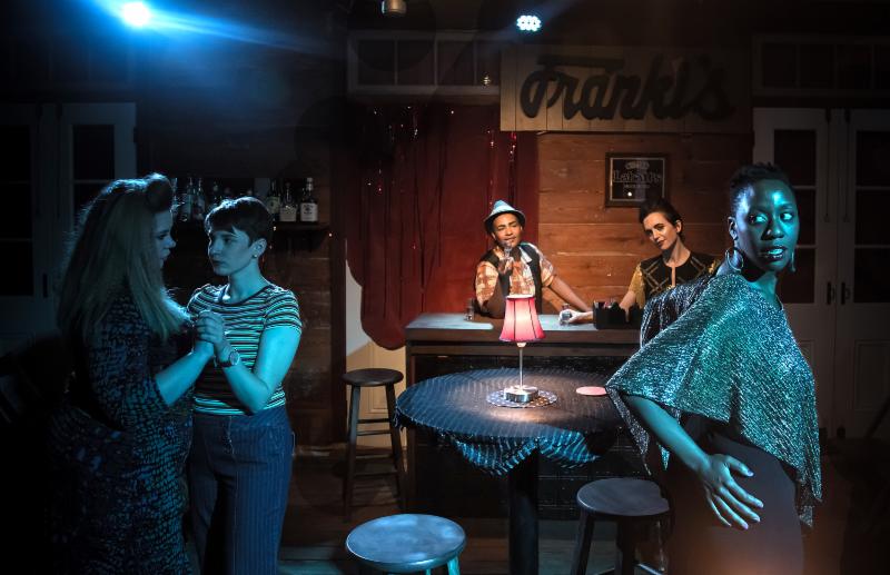 Two women slow dance, two more sit at a bar, and a third stars off camera longingly 