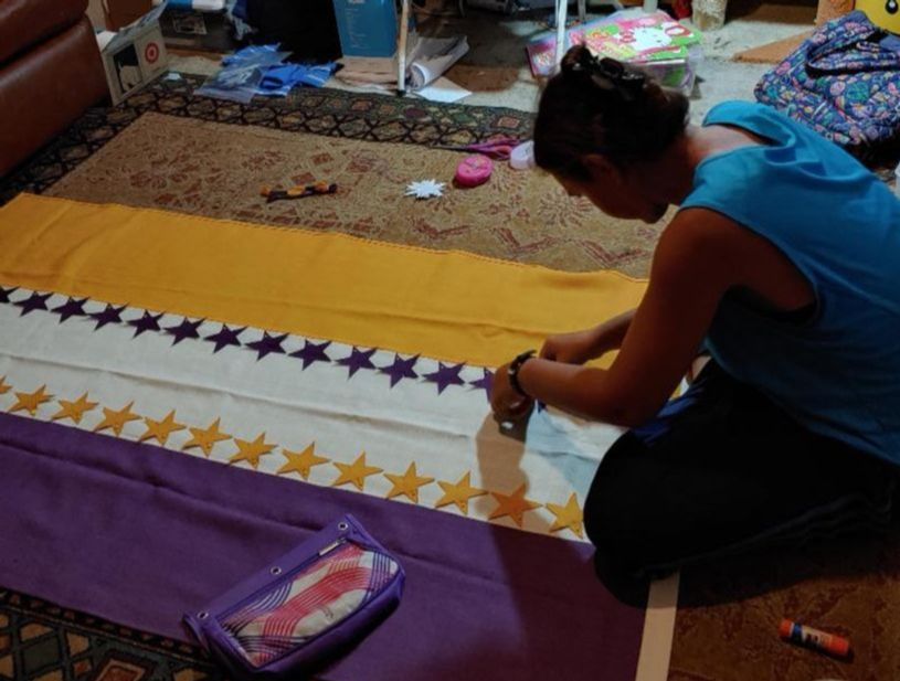 Volunteer Brittney sews stars onto our replica ratification banner - just like Alice Paul.