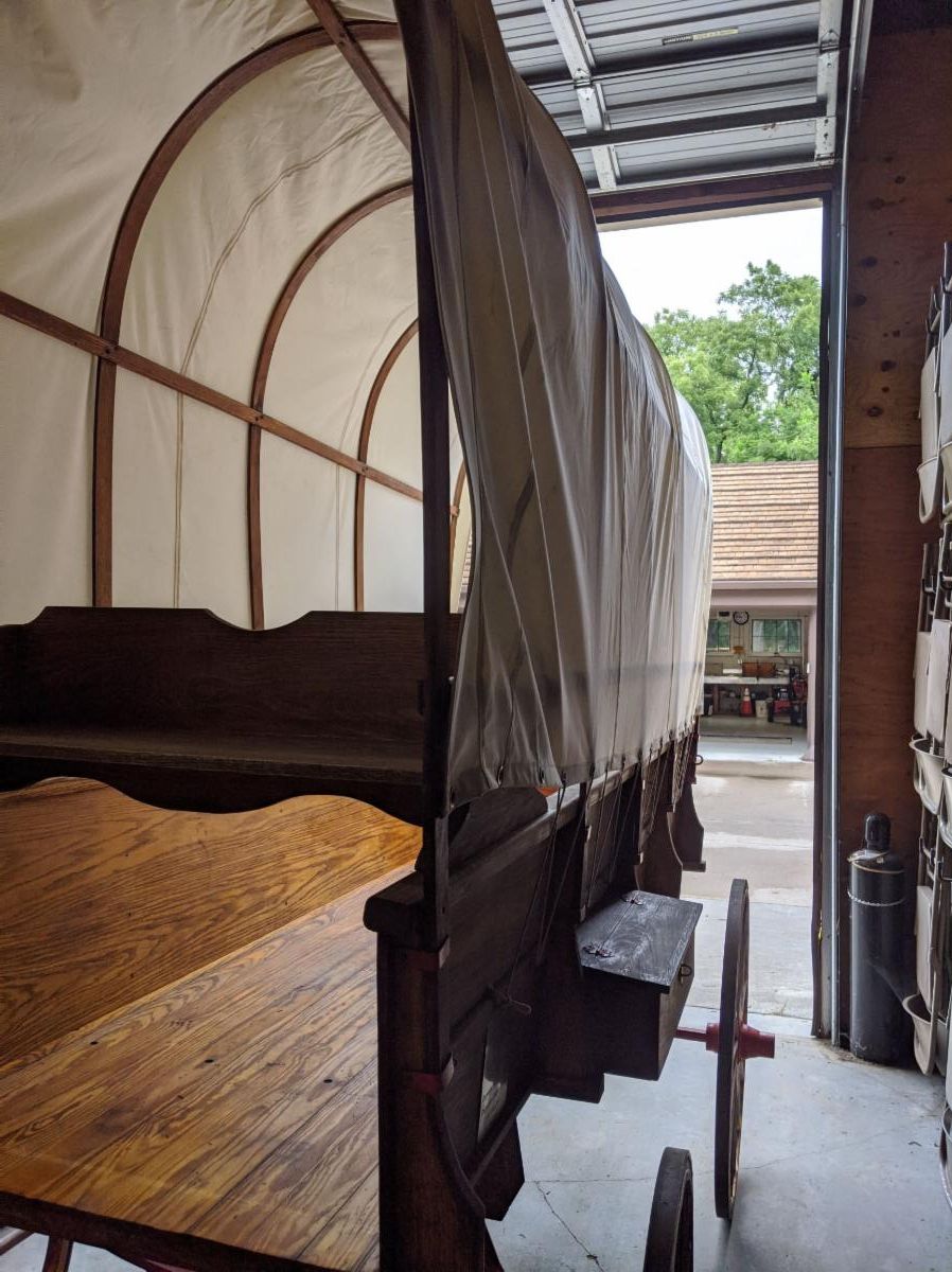 A covered wagon in Homestead_s maintenance bay_ undergoing conservation work.