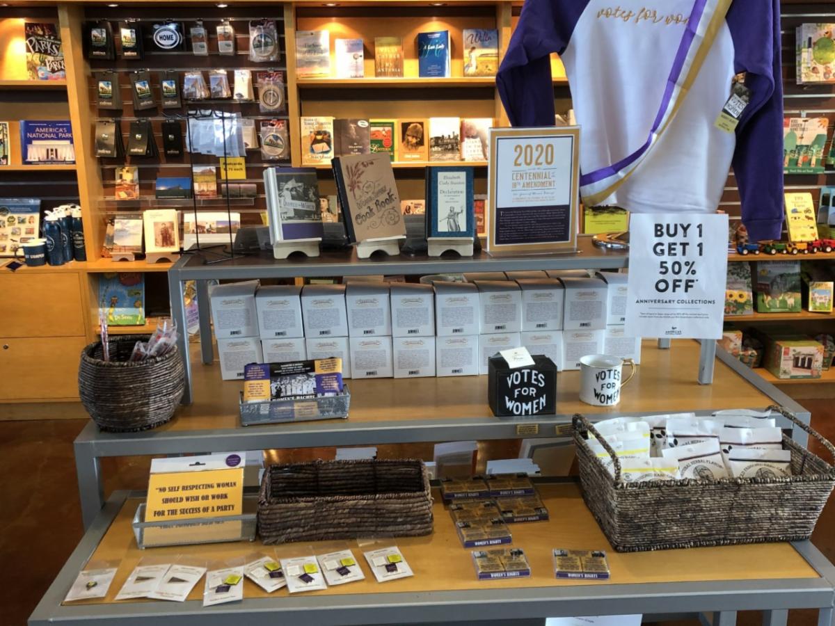 Image of Suffrage Merchandise at Homestead - including mugs_ pings_ books_ and magnets.